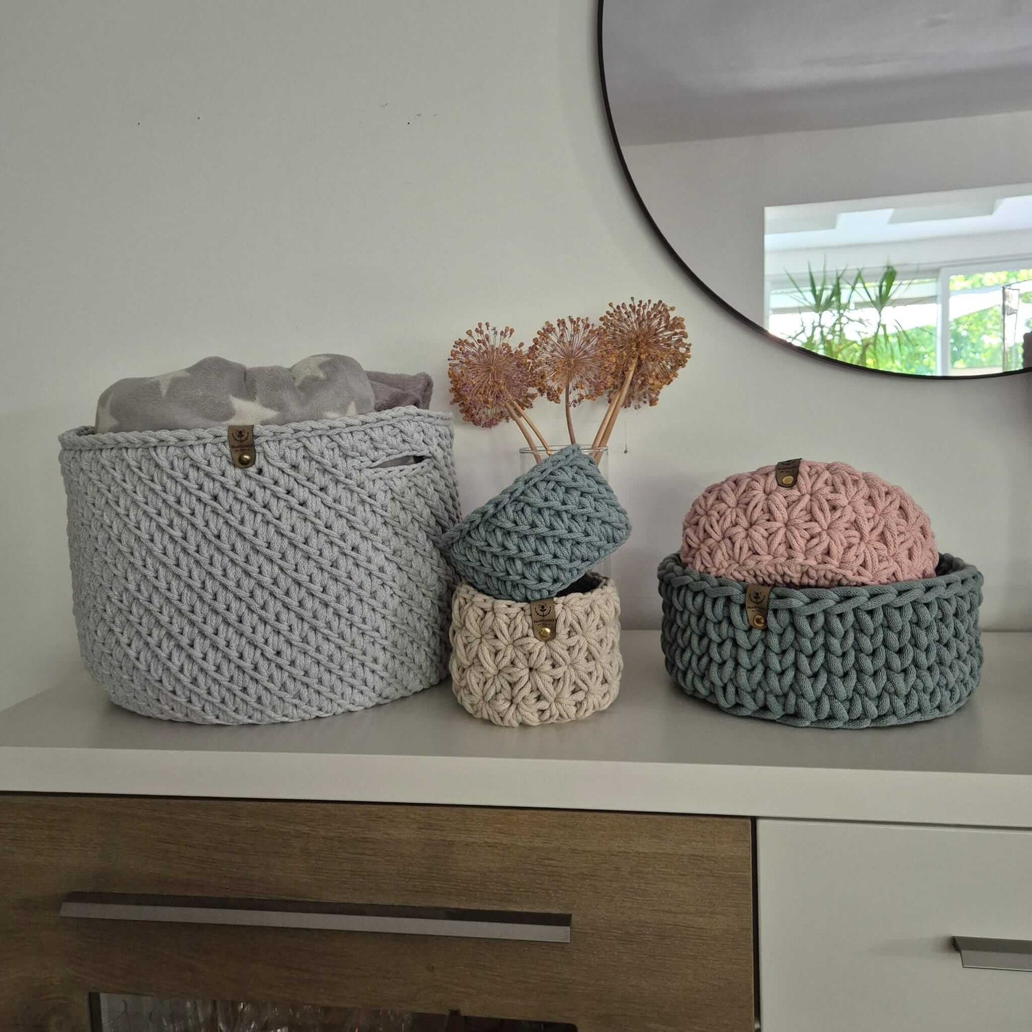 XL Häkelkorb und zwei kleine Körbe aus recycelter Baumwolle auf einer Kommode – natürliche Deko.